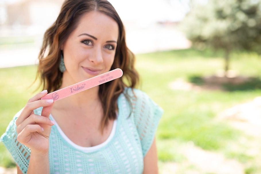 women holding a purple and orange thick sponge nail files, white core