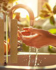 women washing her hands in the sink with the brown Iridesi nail files overlaying the image. The brown nail files have a yellow center and are in the shape called jumbo