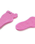 Teenie toe separators. Pink toe separators in the shape of a baby foot. White background. close up of foot print steps.