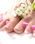 women's foot with the teenie toe separators on with a French pedicure. White background.