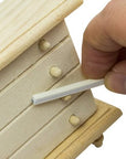 sanding sticks or twigs being used on a miniature wooden dresser