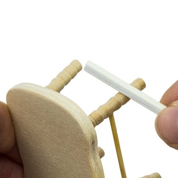 sanding sticks or twigs being used on a mini wooden chair