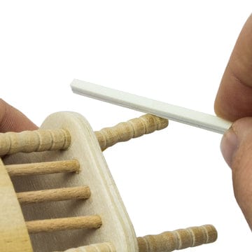 sanding sticks or twigs being used on a mini wooden chair