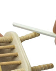 sanding sticks or twigs being used on a mini wooden chair