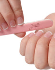 mini pink Iridesi nail files, 3.5 inches long, 1/2 inch wide, Iridesi printed logo, name and grit. White background. In a women's hands with a French manicure.