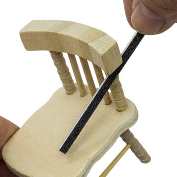 sanding sticks or twigs being used on a mini wooden chair