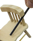 sanding sticks or twigs being used on a mini wooden chair